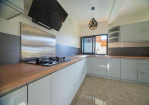 una cucina con mobili bianchi e una stufa di Résidence Kazela a Chirongui