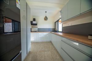 una cucina con mobili bianchi e un piano di lavoro in legno di Résidence Kazela a Chirongui Altre 7 foto