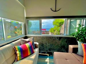 a living room with a couch and two windows at Sea Roots "Sea Zone" in Mosteiros