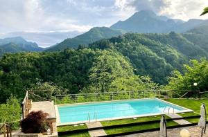 une piscine avec des montagnes en arrière-plan dans l'établissement Ferienhaus In Vergemoli Mit Schönem Kamin, à Vergemoli