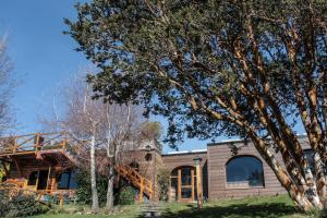 a house with a tree in front of it at Bungalows San Isidro D.T. 114/10 in San Carlos de Bariloche