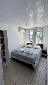 une chambre avec un lit avec deux serviettes dessus dans l'établissement Colonia Home, à Colonia del Sacramento