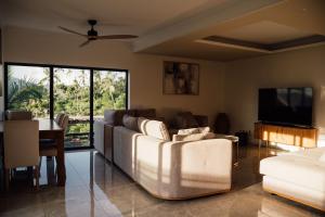 un soggiorno con un divano e una televisione di Résidence Kazela a Chirongui