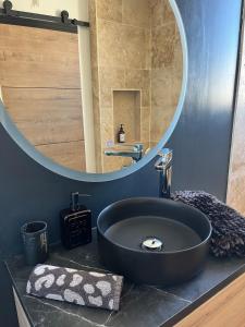 a bathroom with a black sink and a mirror at Cocon jungle bohème 12 min de la mer in Martigues +9 photos
