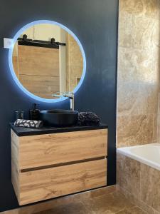 a bathroom with a sink and a mirror and a tub at Cocon jungle bohème 12 min de la mer in Martigues