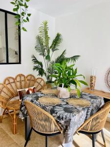a dining room with a table with chairs and plants at Cocon jungle bohème 12 min de la mer in Martigues