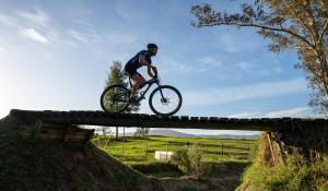 a man riding a bike over a bridge at AfriCamps at Oakhurst in Wilderness