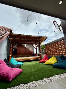 a group of colorful pillows sitting on a lawn at Kalakoala by Zzz in Malang