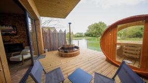 una terrazza con vasca idromassaggio e sedie a bordo di una barca di L'AUTHENTIK - Le Domaine Wambrechies a Wambrechies