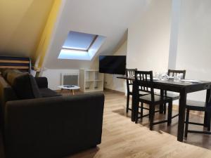 a living room with a couch and a table with chairs at TOK TOK A6 - Appartement 2Ch Toutes commodités in Annoeullin