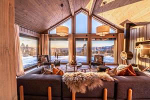 ein Wohnzimmer mit einer Couch und einigen Fenstern in der Unterkunft Luxurious Mountain Lodge in Ljørdal