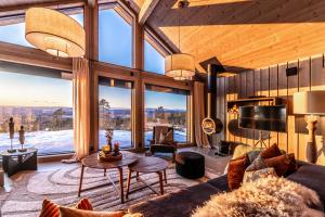ein Wohnzimmer mit Couch und großem Fenster in der Unterkunft Luxurious Mountain Lodge in Ljørdal