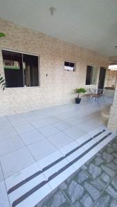 eine weiß geflieste Terrasse mit Stühlen und ein Gebäude in der Unterkunft casa de praia a 5 minutos da praia central in Marataizes