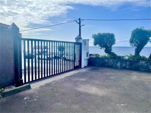 Ein Tor zu einem Haus mit dem Ozean dahinter. in der Unterkunft Sea Roots "Sea Zone" in Mosteiros