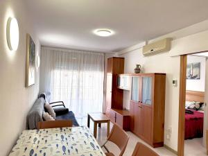 ein Wohnzimmer mit einem Tisch und einem Sofa sowie ein Schlafzimmer in der Unterkunft Apartsalou Zen in Salou