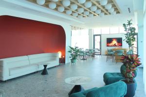 a living room with a white couch and a red wall at Hotel Mooma in Skopje