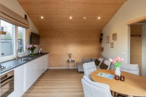 eine Küche und ein Wohnzimmer mit einer Holzwand in der Unterkunft Rekerlanden 260 in Schoorldam