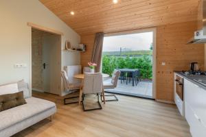 eine Küche und ein Wohnzimmer mit einer Couch und einem Tisch in der Unterkunft Rekerlanden 260 in Schoorldam