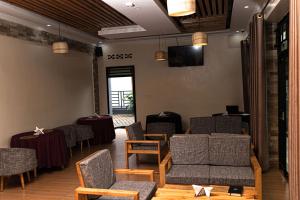 a waiting room with chairs and tables and a television at RP Gorilla Guest & Coffee in Taba +4 photos