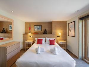 a bedroom with a large white bed with red pillows at Chalet calme avec terrasse, proche pistes, Méribel - FR-1-565-37 in Les Allues