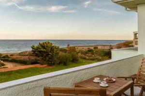 Ein Tisch und Stühle auf einem Balkon mit Blick auf das Meer in der Unterkunft Locanda in Monemvasia