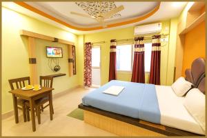 une chambre avec un lit, une table et un bureau dans l'établissement Manisha Road Bhumishree Palace Resort - Free Wifi & Parking Facilities #Fully Air conditioned- Prime Location# Premium Hotel IN Puri, à Purî 1 autre photo