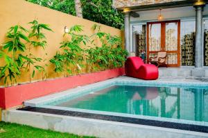 ウナワトゥナにあるSithagi Villa Unawatunaの家の隣にある赤い椅子付きのスイミングプール