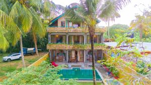 ウナワトゥナにあるSithagi Villa Unawatunaの前にヤシの木がある家