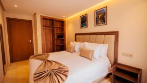 ein Schlafzimmer mit einem Bett mit weißen Laken und Kissen in der Unterkunft Eden Marrakech in Marrakesch + 70 Fotos