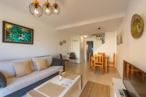 ein Wohnzimmer mit Sofa und Tisch in der Unterkunft Duplex Surla Pájaro vistas al mar in Tarifa