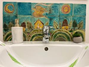 a bathroom sink with a mural on the wall at Victoria Apartment 1901-Apartament ultracentral Oradea ,lângă Piața Unirii in Oradea +21 photos
