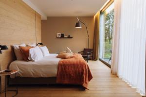 a bedroom with a bed and a large window at Domaine des Terres du Val in Wanze