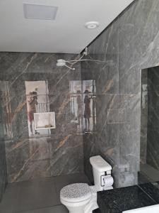 ein Badezimmer mit Toilette und Gemälden an der Wand in der Unterkunft Espaço Teddy Cakes in Campinas