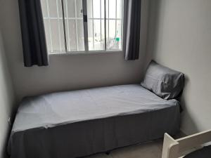 a small bed in a room with a window at Casa com piscina Espaço teddy cakes in Campinas +23 photos
