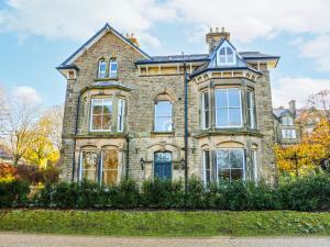 a large brick house with a blue door at Chatsworth Suite in Buxton