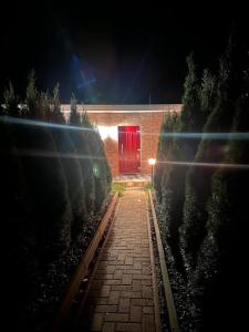 a red door on a brick building at night at Karolinas Deluxe Appartement-Bungalow in Dranske