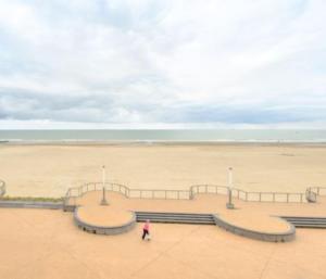 una persona caminando frente a una playa con un parque de patinaje en Sea view 02-04, en Mellet