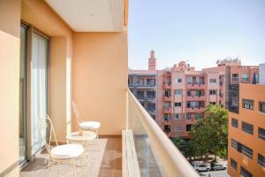 ein Balkon mit zwei Stühlen und einem Tisch auf einem Gebäude in der Unterkunft Eden Marrakech in Marrakesch
