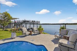 een patio met stoelen en een zwembad naast het water bij All Decked Out and Concierge Services in Kingsland