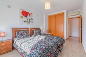 ein Schlafzimmer mit einem Bett, einer Kommode und einer Tür in der Unterkunft Palmeiras Penthouse in Lagos + 14 Fotos