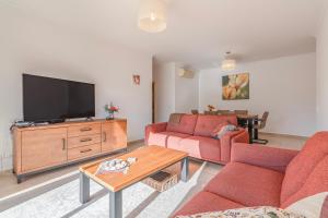 ein Wohnzimmer mit zwei roten Sofas und einem Flachbildfernseher in der Unterkunft Palmeiras Penthouse in Lagos