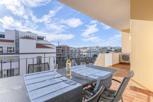 einen Tisch mit einer Flasche Wein auf dem Balkon in der Unterkunft Palmeiras Penthouse in Lagos