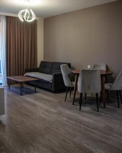 een woonkamer met een bank, een tafel en stoelen bij Crystal Loft Bakuriani Apartment in Bakuriani