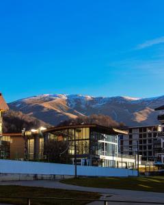 een groot gebouw met een berg op de achtergrond bij Crystal Loft Bakuriani Apartment in Bakuriani