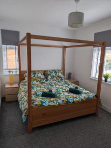 ein Schlafzimmer mit einem Bett mit einem Bettrahmen aus Holz in der Unterkunft Modern, renovated 3 bed home near railway station in North Ferriby