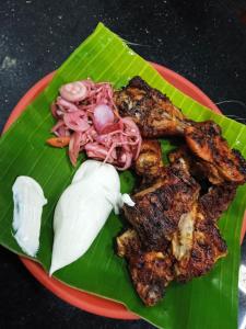 a plate of food with meat and vegetables on a banana leaf at RivoGoa riverside Homestay in Bardez