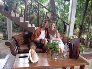 un homme et une femme assis sur un canapé sur une table dans l'établissement Turtle Paradise, à Tangalle