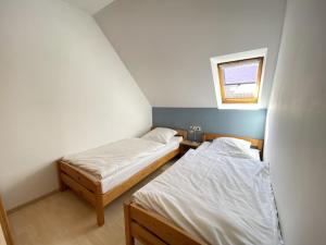 two beds in a small room with a window at Haus 24 im Natur Ferienpark, Perfekt für Hundeliebhaber, Wanderfreunde und Naturliebhaber in Nieheim