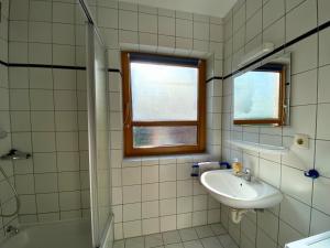 a bathroom with a sink and a toilet and a window at Haus 24 im Natur Ferienpark, Perfekt für Hundeliebhaber, Wanderfreunde und Naturliebhaber in Nieheim