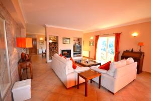 ein Wohnzimmer mit 2 weißen Sofas und einem Kamin in der Unterkunft Villa Vida Nova in Monchique